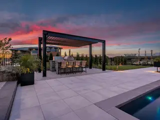Outdoor kitchen with pergola on large-format pavers