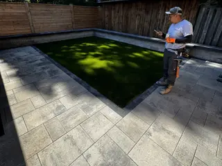 Artificial turf inlay framed in pavers — Golden Maple project in Orillia