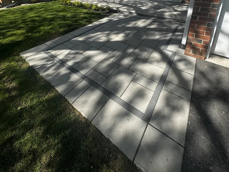 Large-format slab walkway with a dark border set into a front lawn in Barrie, ON