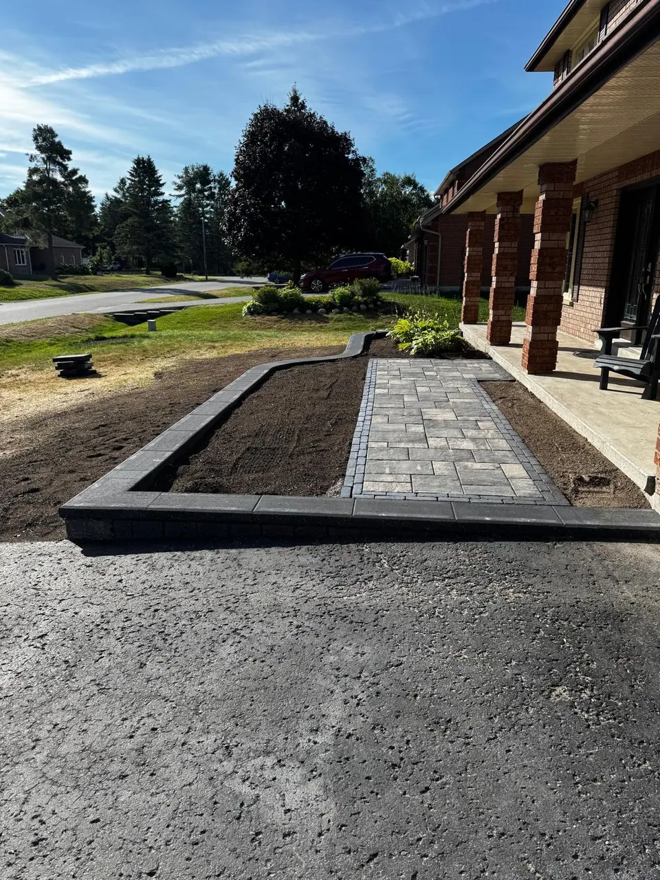 Paver walkway and front entrance between brick pillars with new planting beds in Midhurst, ON