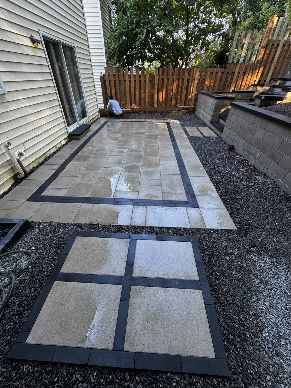 Slab patio with a dark border and stepping pads set in gravel along a side yard in Simcoe County, ON